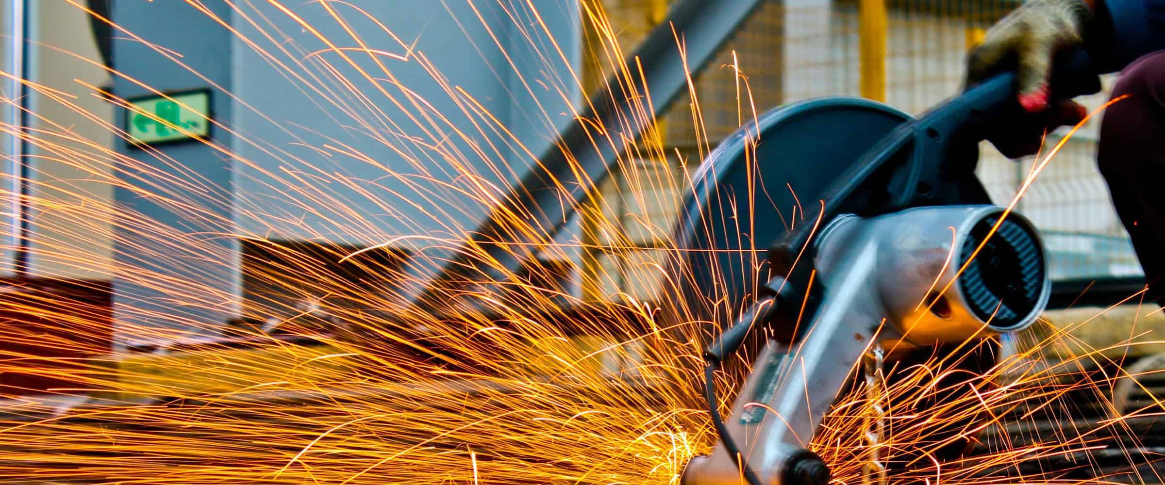 a picture of a power saw with orange sparks flying out from it.